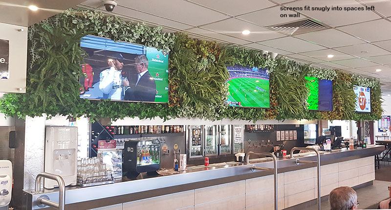 sports bar uses greenery to frame screens