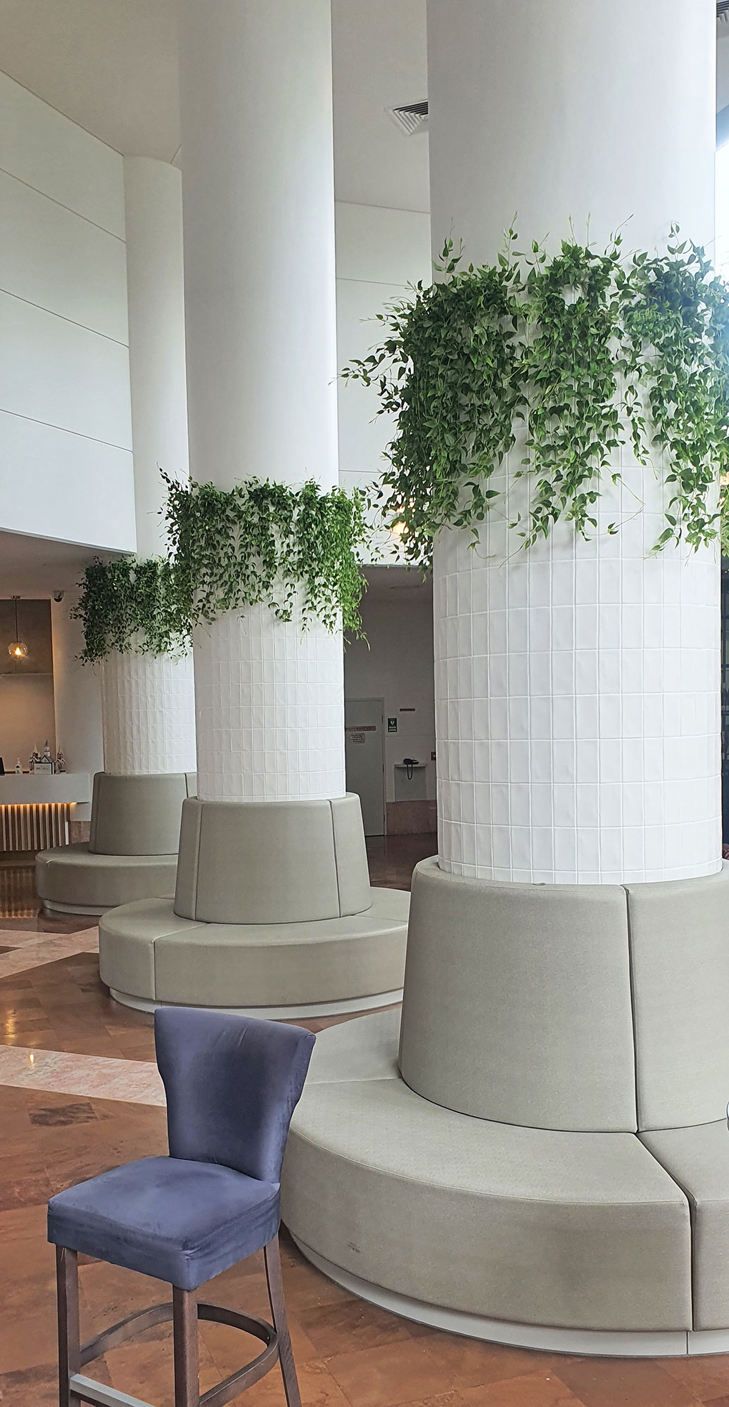 Columns in foyer are softened by greenery
