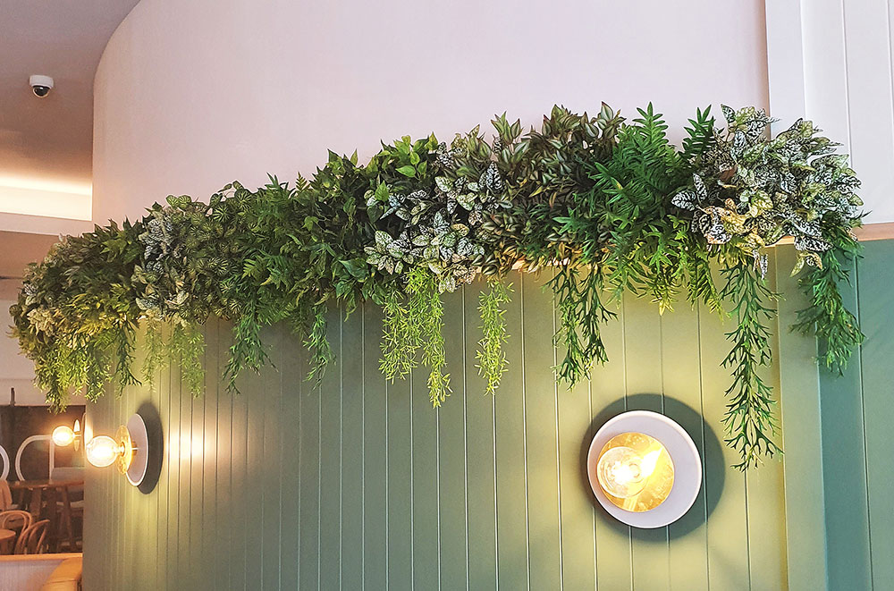 softening up Hotel decor with greenery on walls