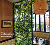 Cafe uses artificial green-vines for privacy screens & pergolas