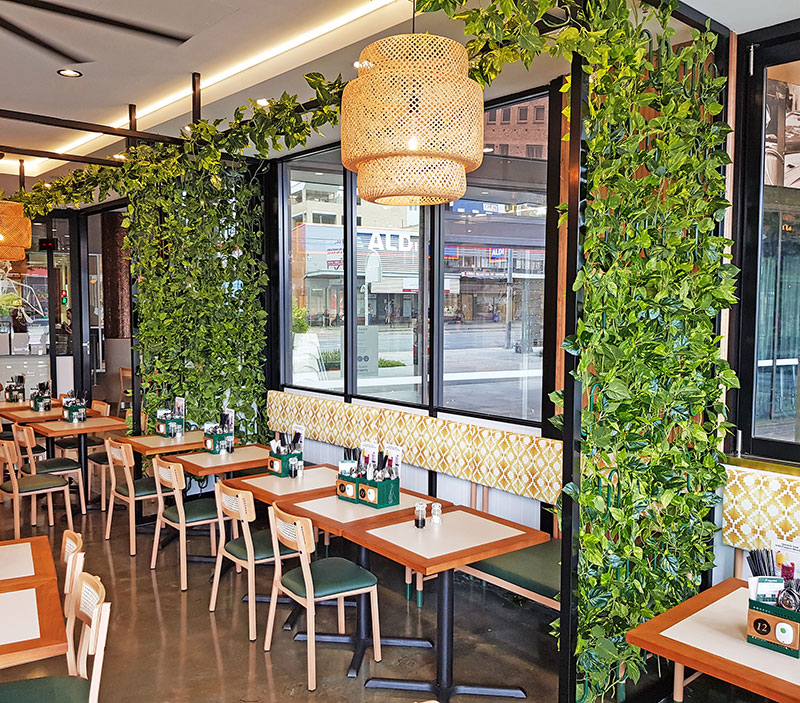 Cafe uses artificial green-vines for privacy screens & pergolas