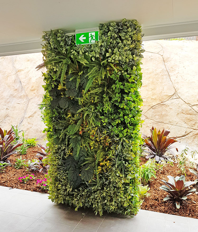 Ugly block support walls turned into lush green-screens with artificial plants image 5
