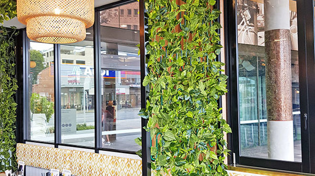 Cafe uses artificial green-vines for privacy screens & pergolas