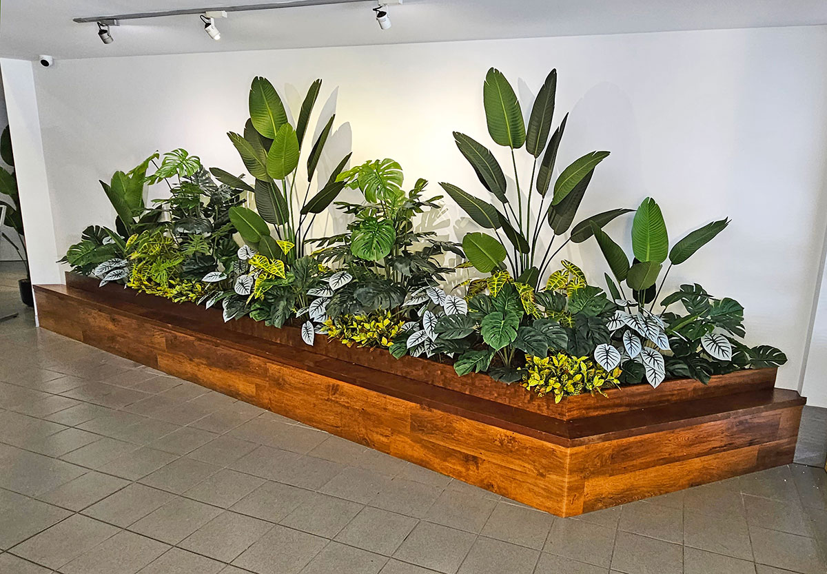 lush mixed tropical plants in foyer planter-box